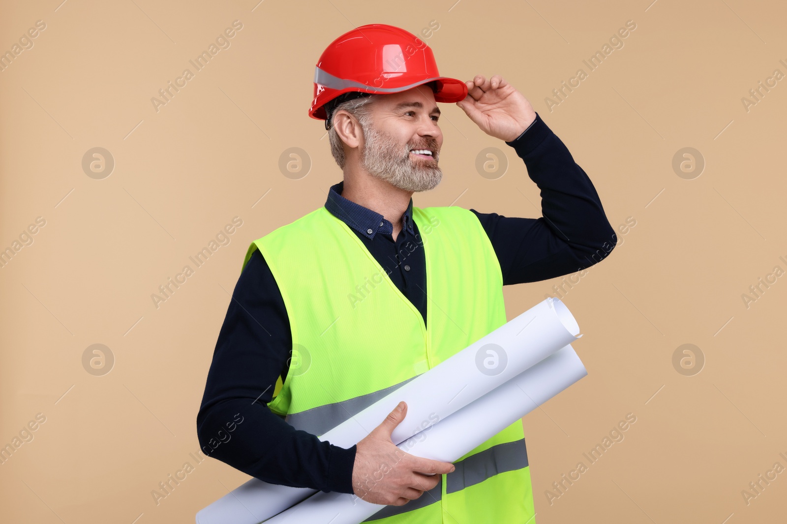 Photo of Architect in hard hat holding drafts on beige background