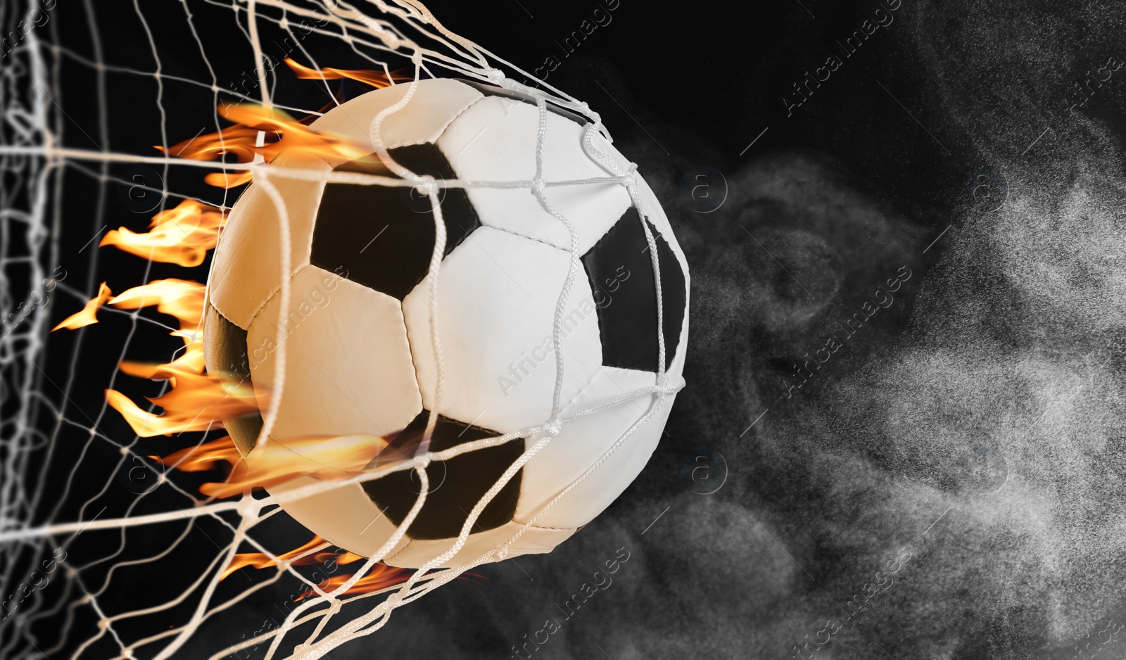 Image of Soccer ball with fire in net against black background