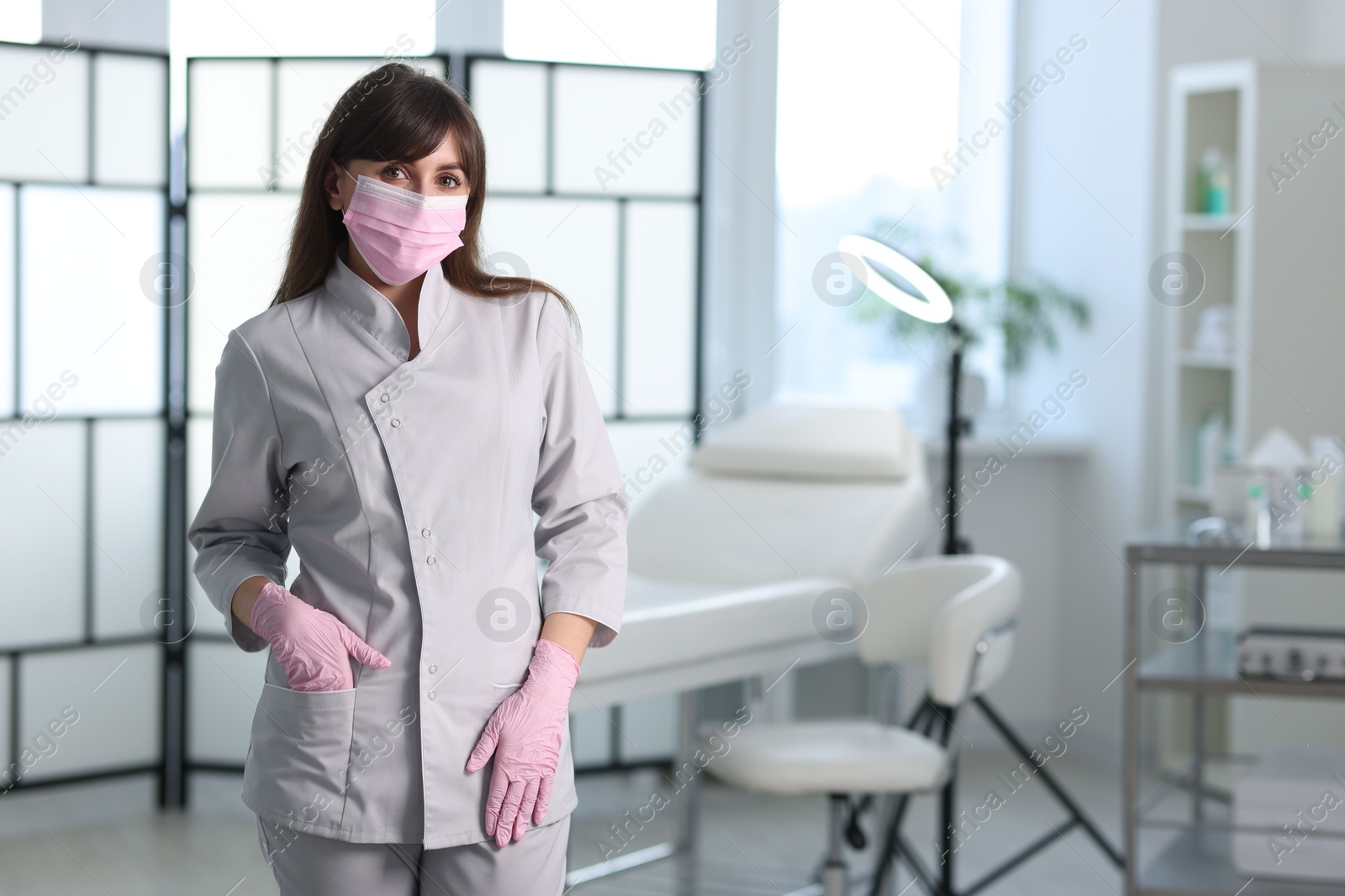 Photo of Cosmetologist in medical uniform in clinic, space for text