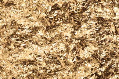 Photo of Crumpled gold foil as background, top view