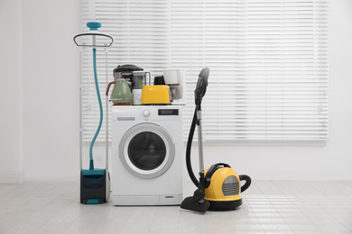 Photo of Different household appliances near window in room