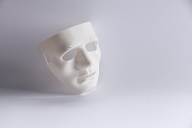 Photo of Plastic face mask on white background, space for text. Theatrical performance