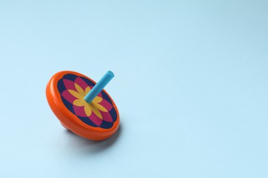 Photo of One colorful spinning top on light blue background