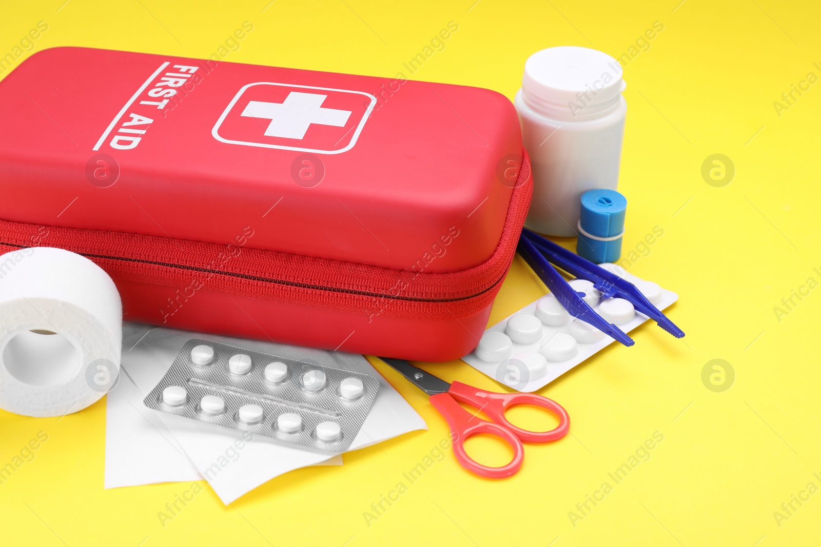 Photo of First aid kit on yellow background, closeup