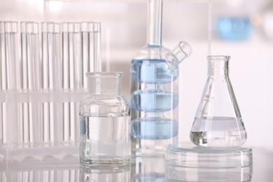 Laboratory analysis. Different glassware with liquid on white table against blurred background