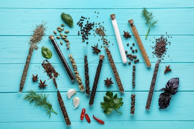 Photo of Flat lay composition with various spices, test tubes and fresh herbs on light blue wooden background