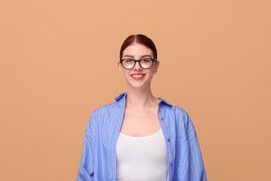 Photo of Portrait of smiling woman in glasses on beige background