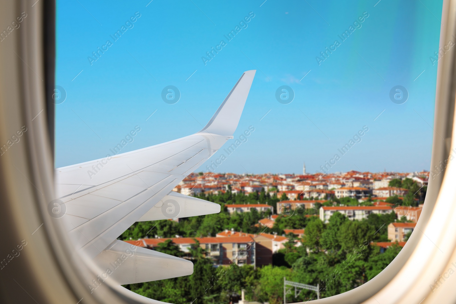 Image of Beautiful city with buildings, view through airplane window during flight