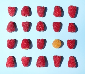 Photo of Flat lay composition with delicious ripe raspberries on blue background