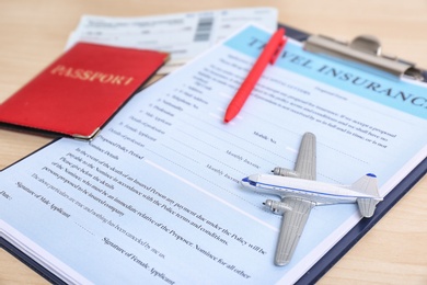 Photo of Composition with toy plane and travel insurance form on table