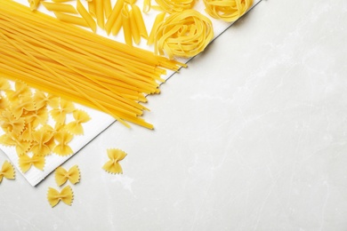 Photo of Beautiful composition with different raw pasta on table, top view