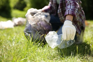 Woman with plastic bags collecting garbage in park