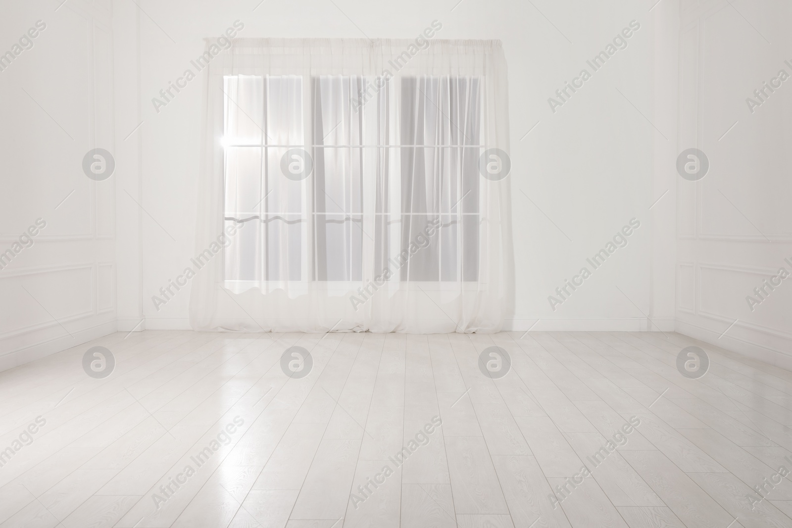 Photo of Empty room with white walls and large window