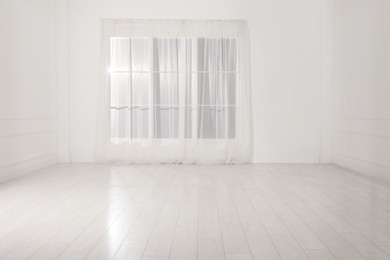 Empty room with white walls and large window