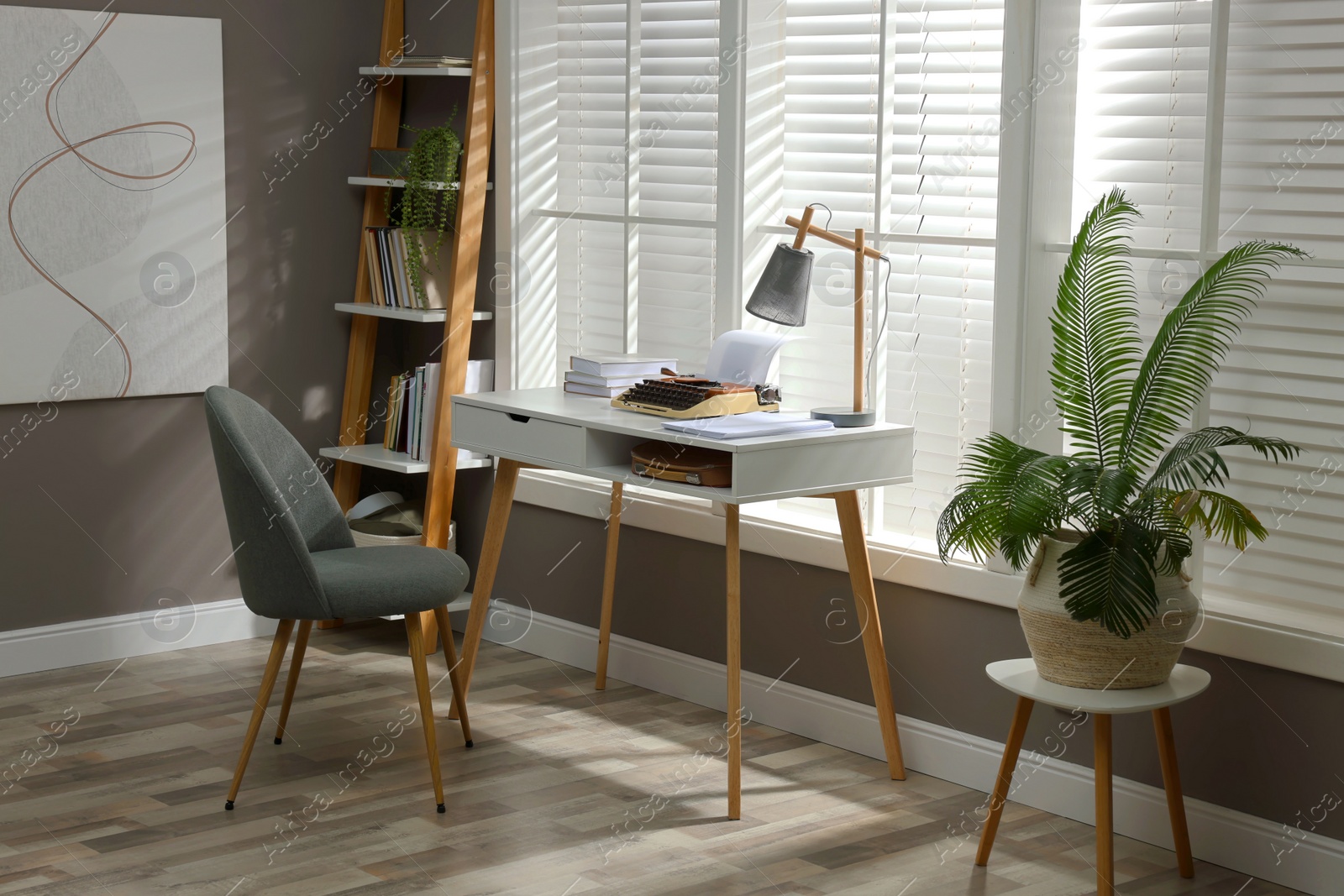 Photo of Comfortable writer's workplace interior with typewriter on desk in front of window