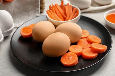 Naturally painted Easter eggs on light grey table, closeup. Carrot used for coloring