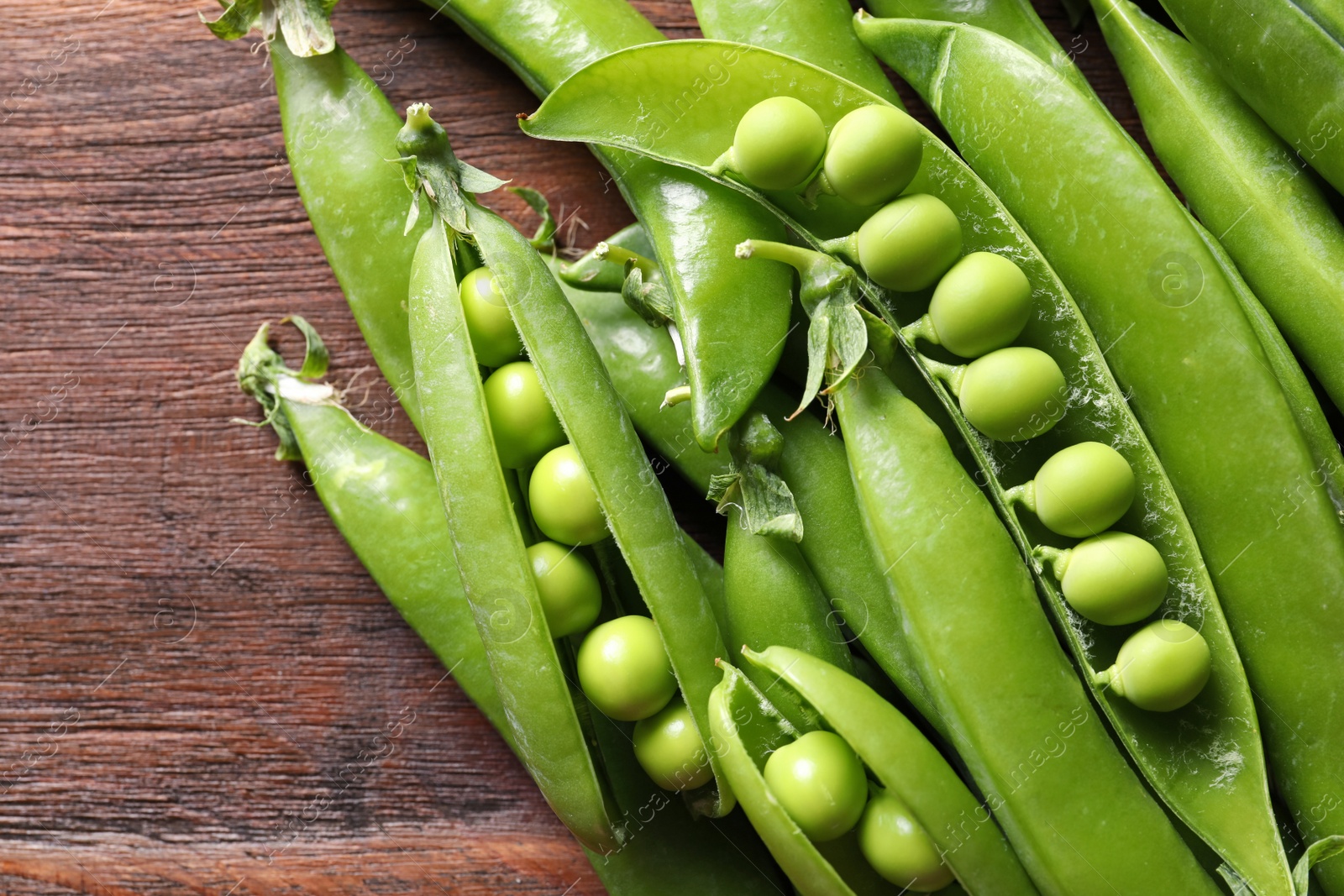 Photo of Fresh green peas on wooden background, closeup