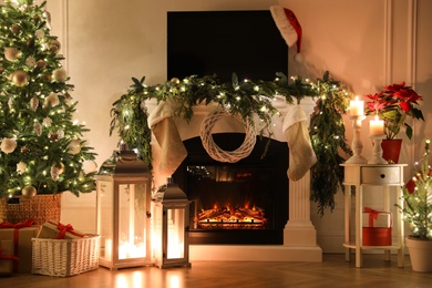 Beautiful room interior with fireplace and Christmas decor in evening