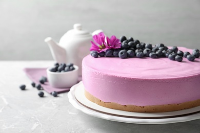 Plate with tasty blueberry cake on light grey table. Space for text