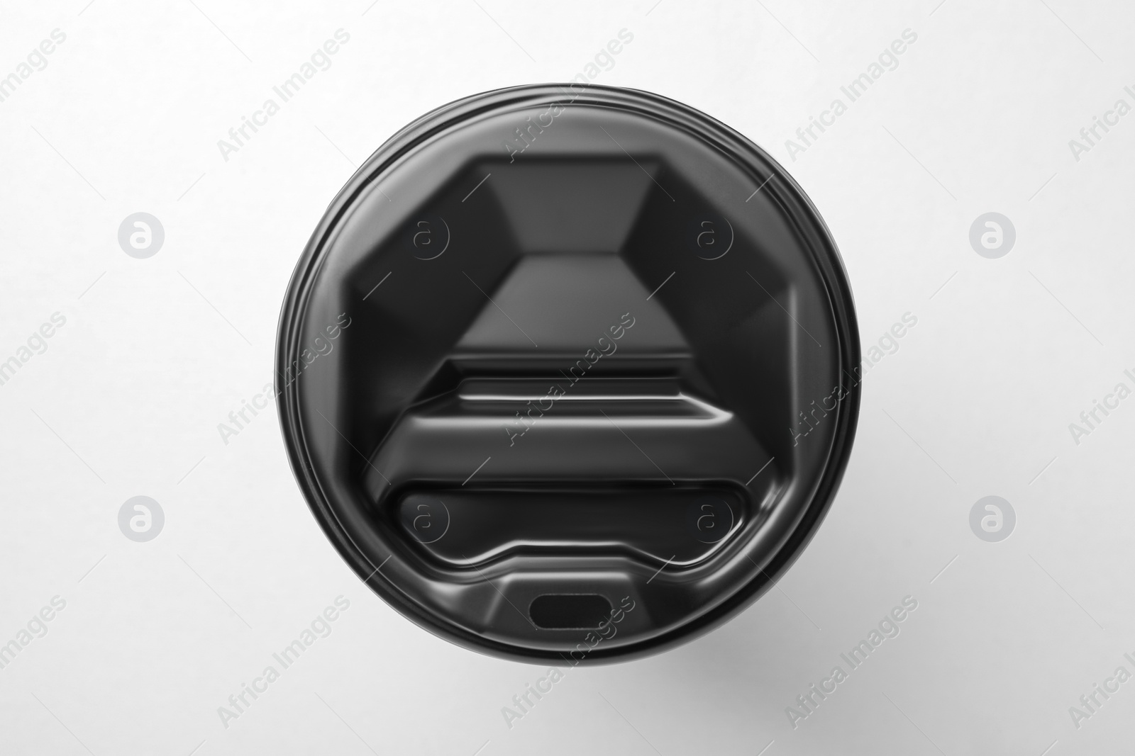 Photo of One paper cup with black lid on light grey background, top view. Coffee to go