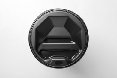 Photo of One paper cup with black lid on light grey background, top view. Coffee to go