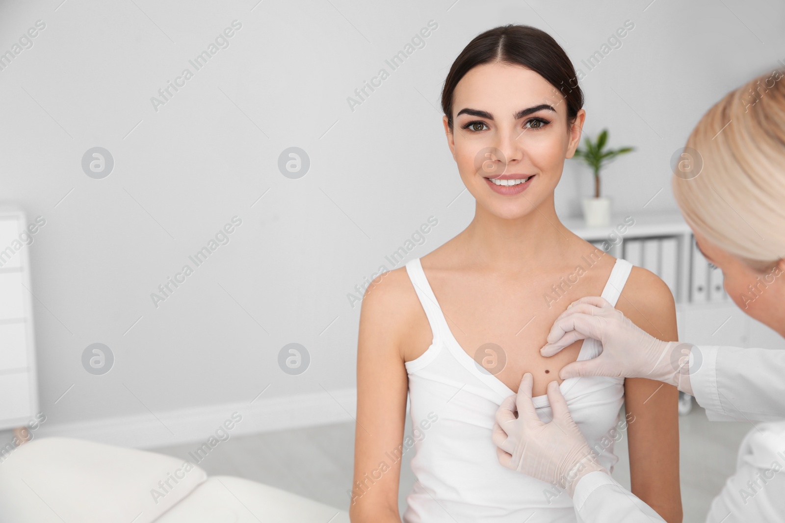 Photo of Dermatologist examining young patient's birthmark in clinic