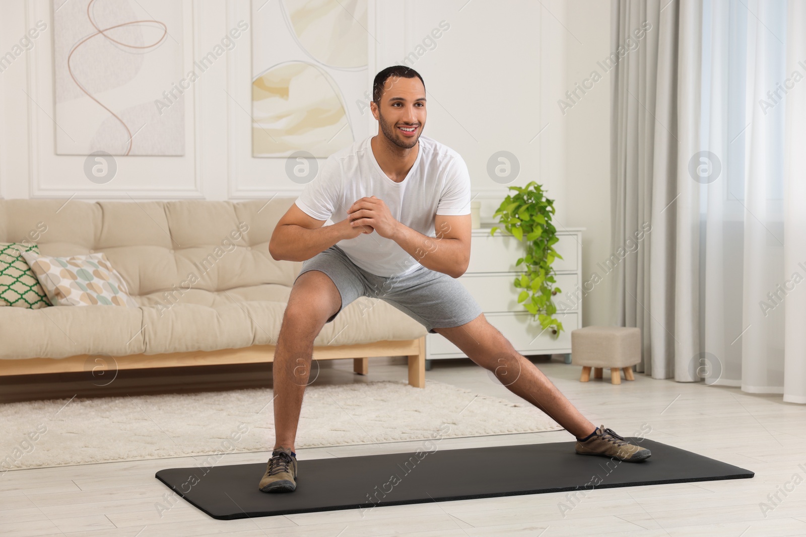 Photo of Man doing morning exercise on fitness mat at home