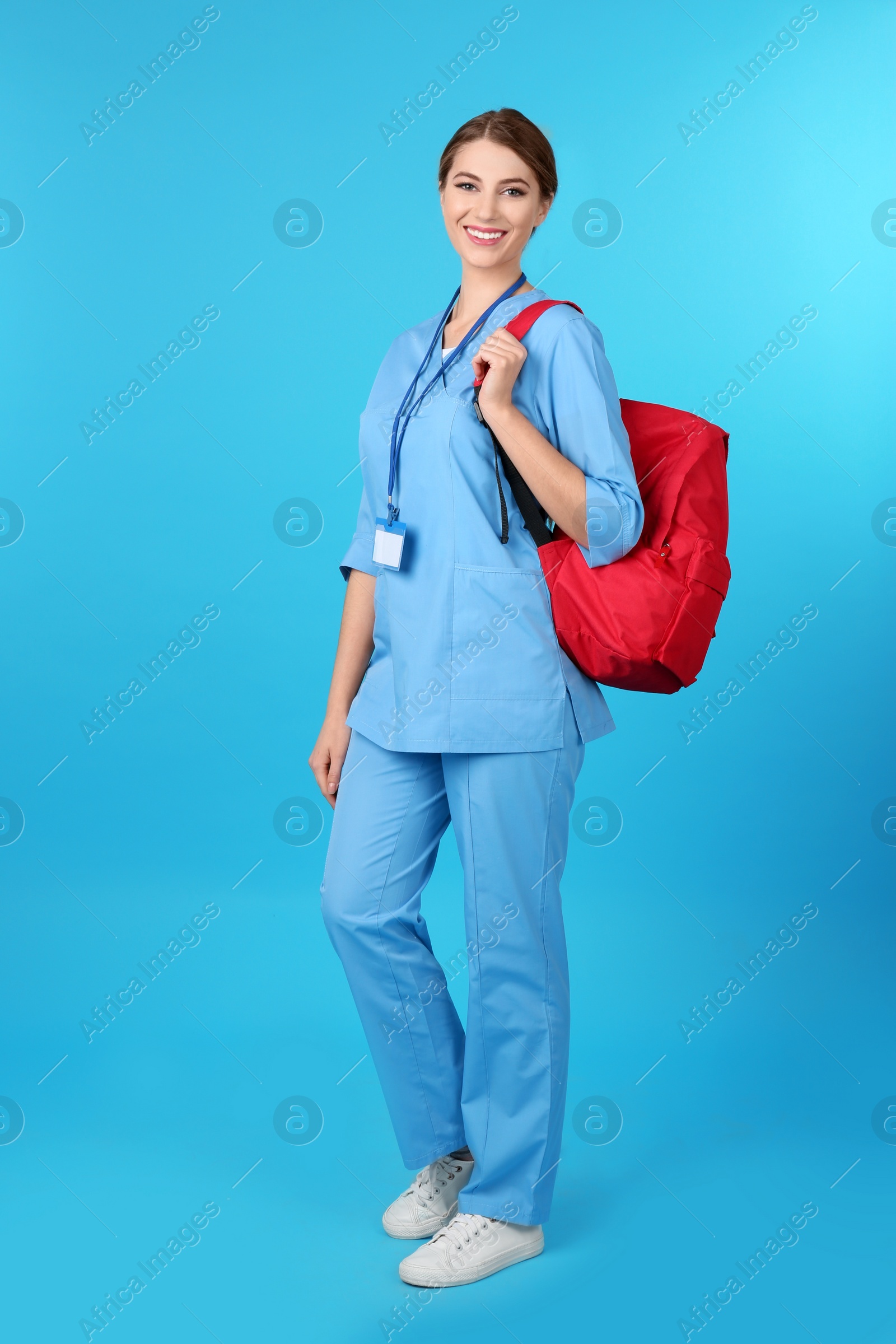 Photo of Young medical student with backpack on color background