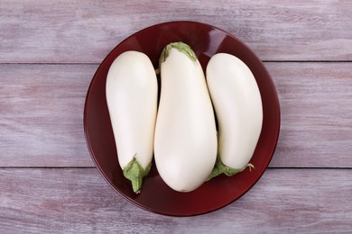 Fresh white eggplants on wooden table, top view