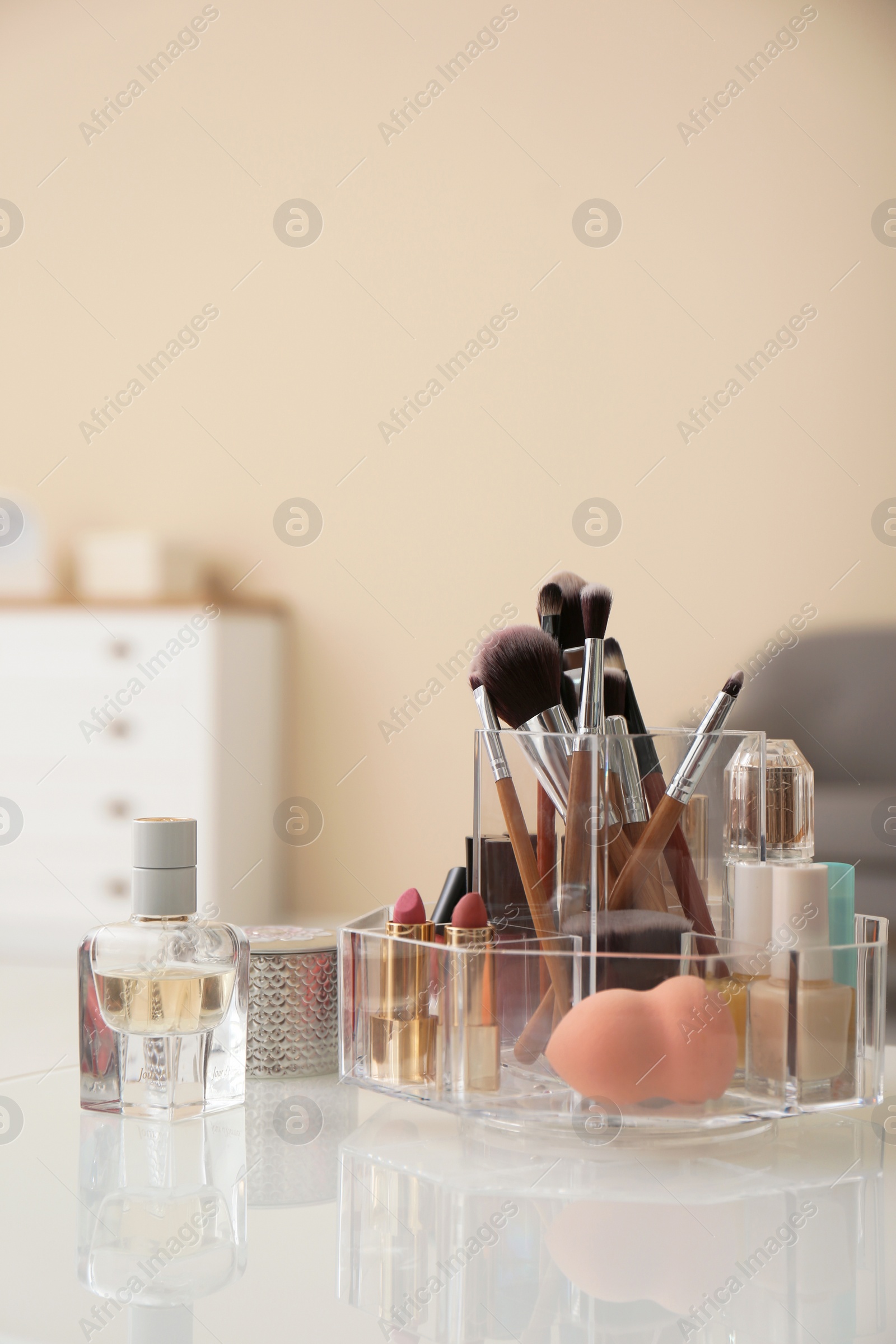 Photo of Organizer with cosmetic products for makeup on table indoors