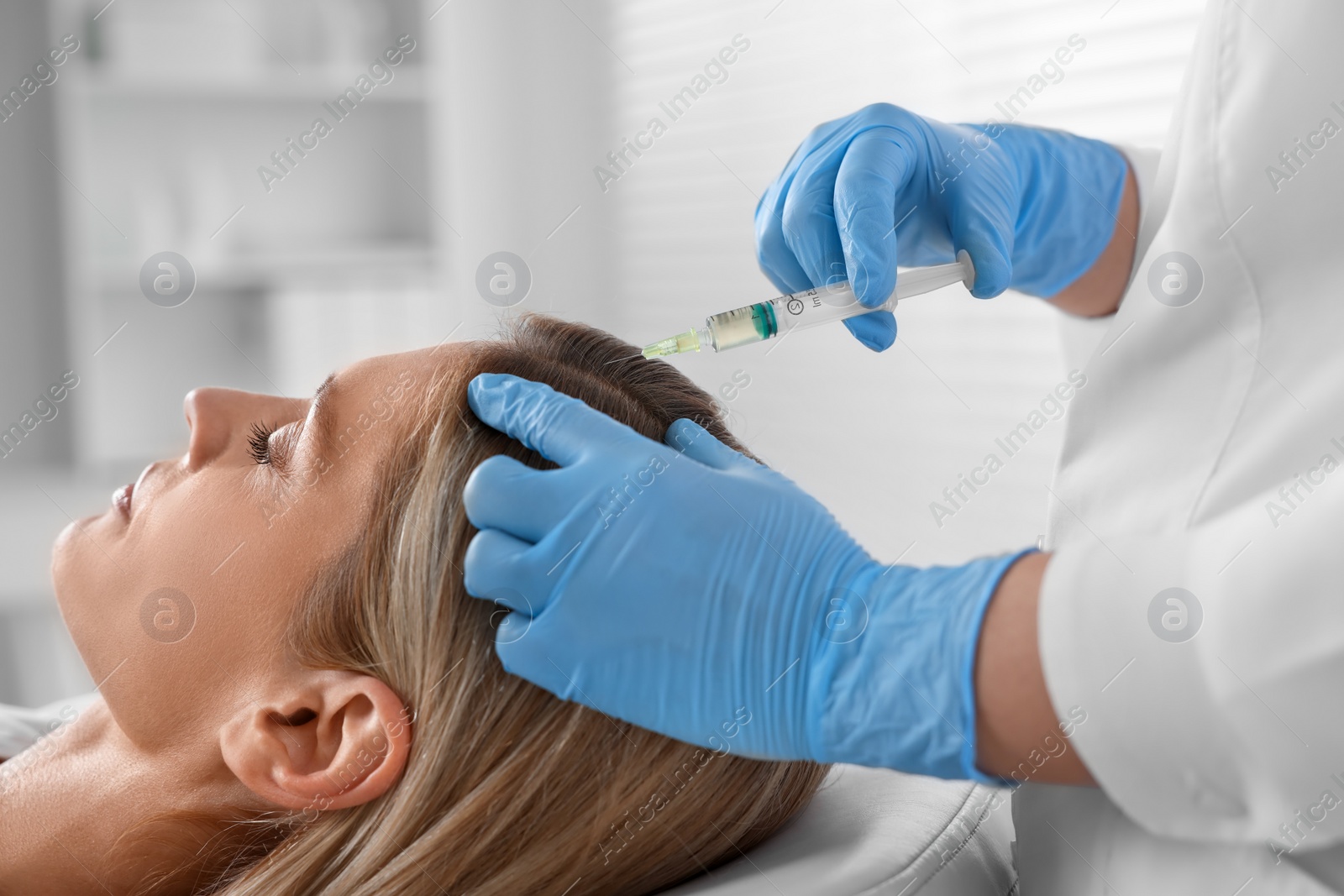 Photo of Trichologist giving injection to patient in clinic, closeup