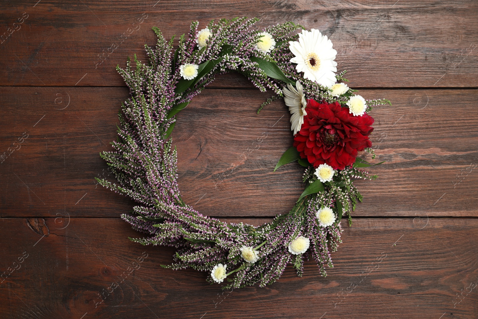 Photo of Beautiful autumnal wreath with heather flowers on wooden background, top view. Space for text