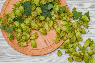 Board and fresh green hops on pale blue wooden table, flat lay
