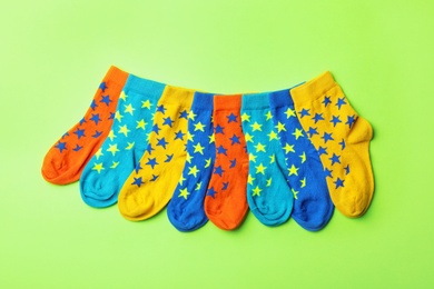 Photo of Cute child socks on color background, top view