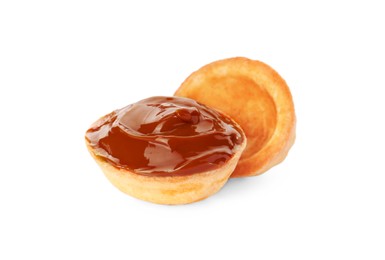 Photo of Halves of delicious nut shaped cookie with boiled condensed milk on white background