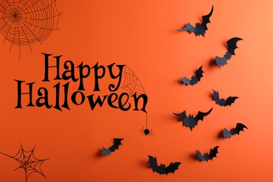 Image of Happy Halloween. Paper bats on orange background, flat lay