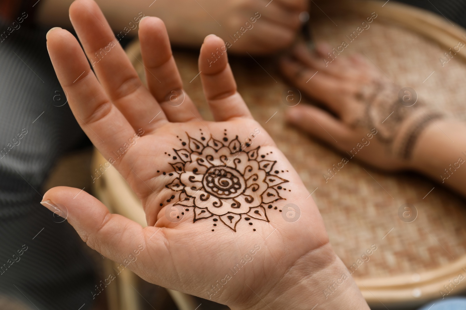 Photo of Master making henna tattoo, focus on hand. Traditional mehndi