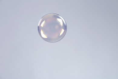 Beautiful translucent soap bubble on grey background