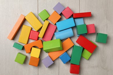 Colorful building blocks on wooden floor, flat lay