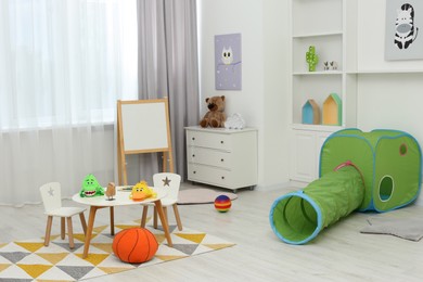 Photo of Child`s playroom with different toys and modern furniture. Stylish kindergarten interior