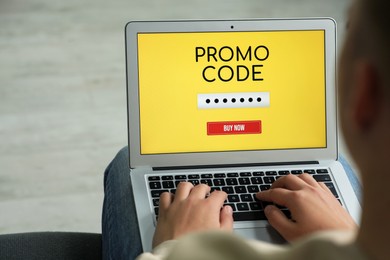 Photo of Woman with laptop activating promo code while doing online shopping, closeup