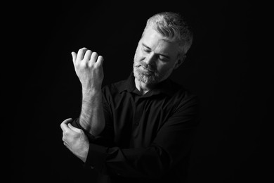 Photo of Portrait of handsome man on dark background. Black and white effect