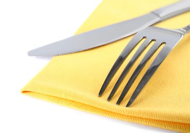 Photo of Yellow napkin with fork and knife on white background, closeup