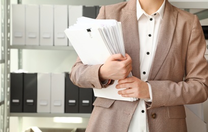 Female worker with documents in archive, closeup. Space for text