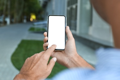 Photo of Man using modern mobile phone outdoors, closeup