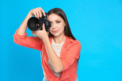 Photo of Professional photographer working on light blue background in studio