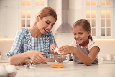 Mother and daughter making dough together in kitchen