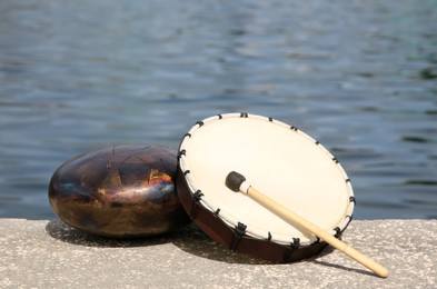 Different drums and drumstick near sea. Percussion musical instruments