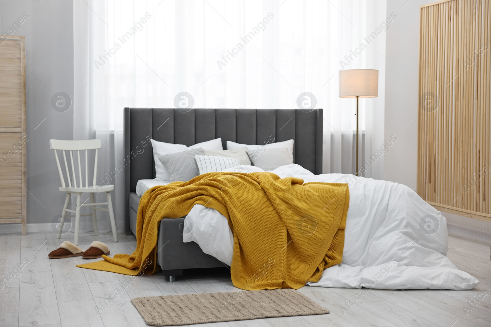 Photo of Bright plaid on bed in stylish bedroom