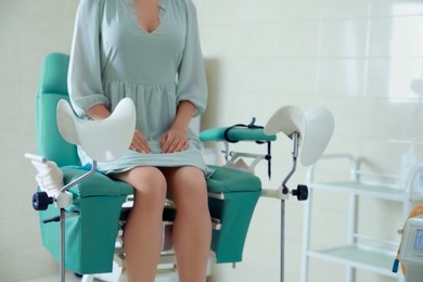 Photo of Gynecological checkup. Woman sitting on examination chair in hospital, closeup